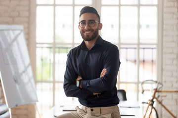 Portrait of smiling Arabian male boss posing in office
