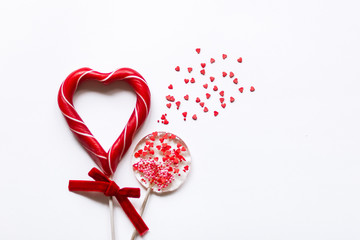 round candy and a heart shaped Lollipop symbolizing love on a white background