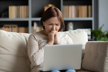 Upset senior woman read bad news on laptop at home - Powered by Adobe