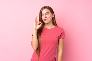 Teenager blonde girl over isolated pink background showing an ok sign with fingers