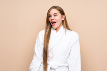 Obraz premium Teenager girl in a bathrobe over isolated background with surprise facial expression