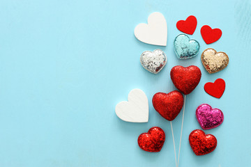 Fototapeta premium Valentines day concept. red glitter hearts over wooden blue background. Flat lay composition