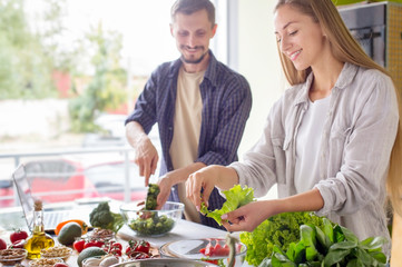 Handsome man and attractive young woman cooking together