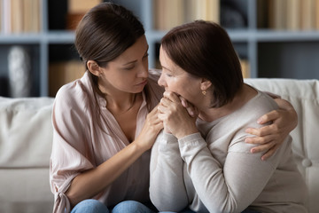 Loving grownup daughter support comfort upset senior mum