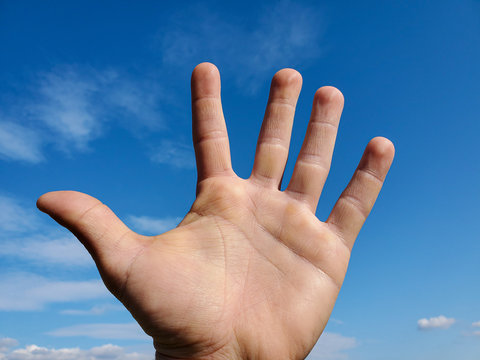 Human hand over clear blue sky background,man power concept, freedom