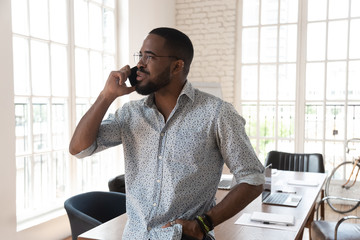African American male employee speak on cellphone in office