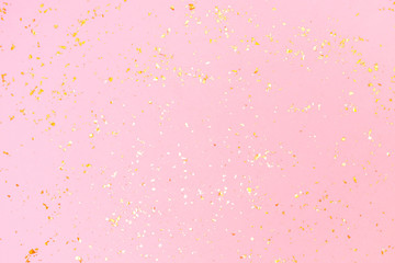 Golden sparkles on pink pastel trendy background. Festive backdrop for your projects.