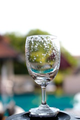 glass of water on green background of blue sky