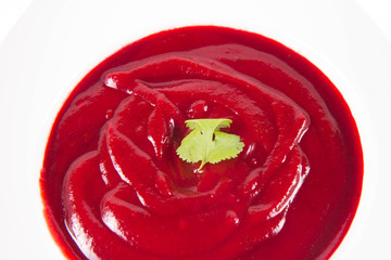Beetroot cream soup decorated with coriander leaf