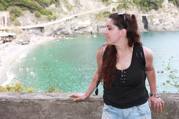 brunette caucasian curvy girl on a lookout point on the Cinque Terre coast in summer