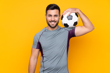 Man over isolated yellow background with soccer ball