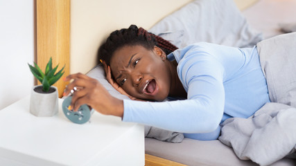 Woman Turning Off Alarm-Clock Screaming Touching Head Lying In Bed