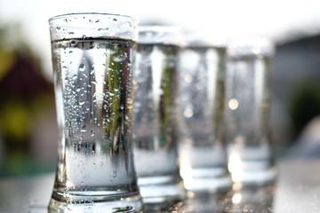 glass of water with ice on green background