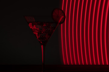 Glass of martini with ice shot in a long exposure in neon light