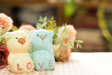 Ceramic Statues Little bear lovers with flower decoration blur background. Valentine Concept.Vintage and Instragram style