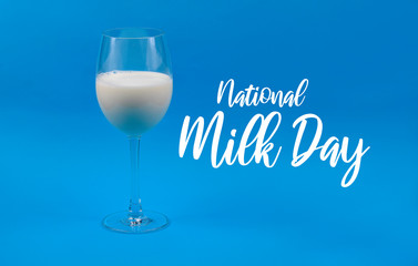 National Milk Day. Glass of milk on a blue background stock images. Milk in a wine glass. Wine glass with milk on a blue background