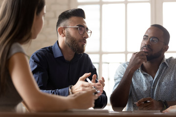 Multiethnic colleagues talk discussing business ideas at meeting