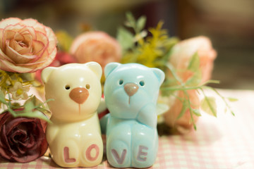 Ceramic Statues Little bear lovers with flower decoration blur background. Valentine Concept.Vintage and Instragram style