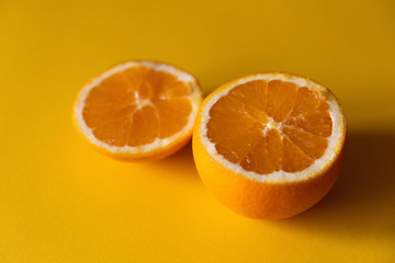 two halves of orange on yellow background