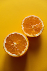 two halves of orange on yellow background