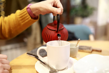 Fototapeta na wymiar Person pouring herbal tea