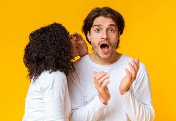 African American Girl Whisperring Gossips To Her Shocked Boyfriend