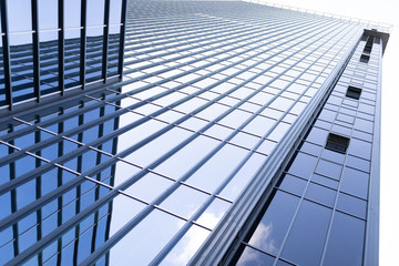 Fototapeta premium Tall modern business center building with glass office building and sky reflection