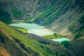 Naklejka premium Aerial spectacular view to scenic valley with two beautiful mountain lakes, conifer forest and rocky mountains. Amazing atmospheric highland landscape. Wonderful majestic wilderness nature scenery.
