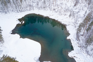 Aerial view of a blue and green lake with snow in winter in the Altai mountains in Russia. Nature and scenic spots.