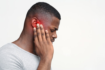 Man having ear pain, touching his painful head - obrazy, fototapety, plakaty