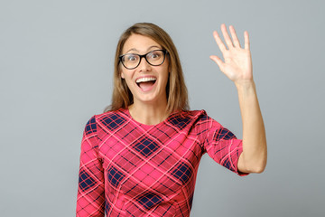 Young cheerful beautiful woman waiving saying hello