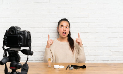 Young blogger Asian girl recording a video tutorial pointing with the index finger a great idea