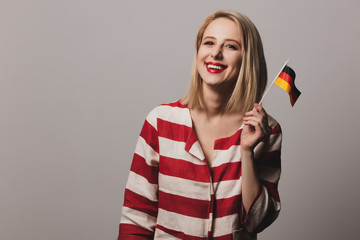 beatiful blonde girl holds German flag in hand