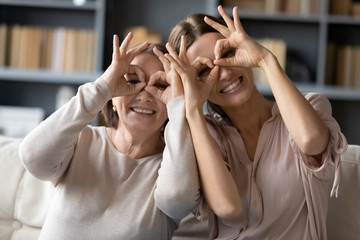 Excited adult mother and daughter make funny gestures posing