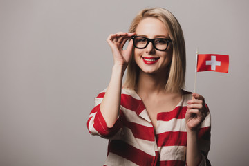 girl holds Switzerland flag on gray backgrou