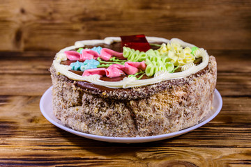 Kiev cake with cream, nuts and meringue on a wooden table