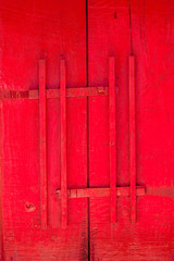 Red door of church with wood latch Thai traditional style, antique wooden door Buddhist temple gate with wooden door red color vintage style