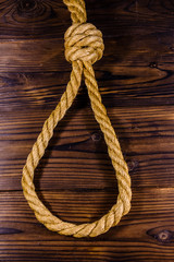 Rope with noose for the suicide on wooden background