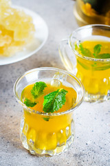 Oriental tea with mint with oriental sweets on grey concrete table background. Ramadan drink