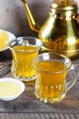 Oriental tea with honey and oriental sweets navat on wooden table background. Ramadan drink