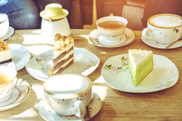 Happiness female friends meeting and drinking tea or coffee with cakes together at cafe in the afternoon. People, leisure and communication concept. Selective focus.