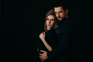 elegant couple in the tender passion. man embracing beautiful woman in black dress