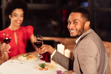 Cheerful Couple Holding Wine Glasses Smiling Celebrating Valentine In Restaurant