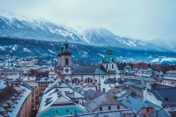 Naklejka na ściany i meble Aerial church view in Innsbruck with snow covered mountains on the background