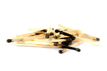 A pile of burnt matches on a white background with shadow. A lot of burnt matches on a white background. Fire hazard - matches. A pile of burnt matches isolated on a white background.