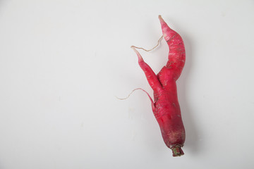 Ugly radish on a white background. horizontal. Ugly raw vegetables on white