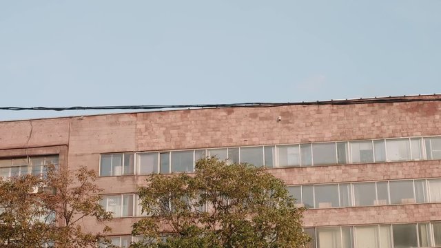 Two bikers on cycles BMX perform thei trix. Old building on backgournd.