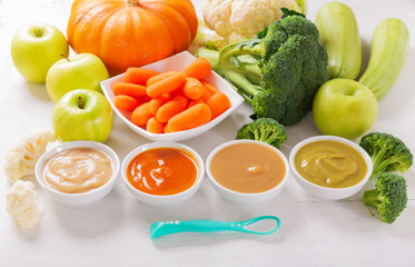 Baby food. Various kinds of bowls of fruit and vegetable puree with ingredients for cooking, top view