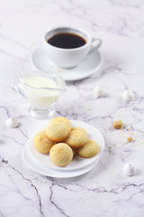 Little round Vanilla Butter Cookies, round box, plate, coffee, light marble background.