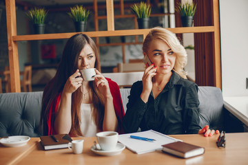 Pretty businesswomen working. Cute girls sitting at the caffee